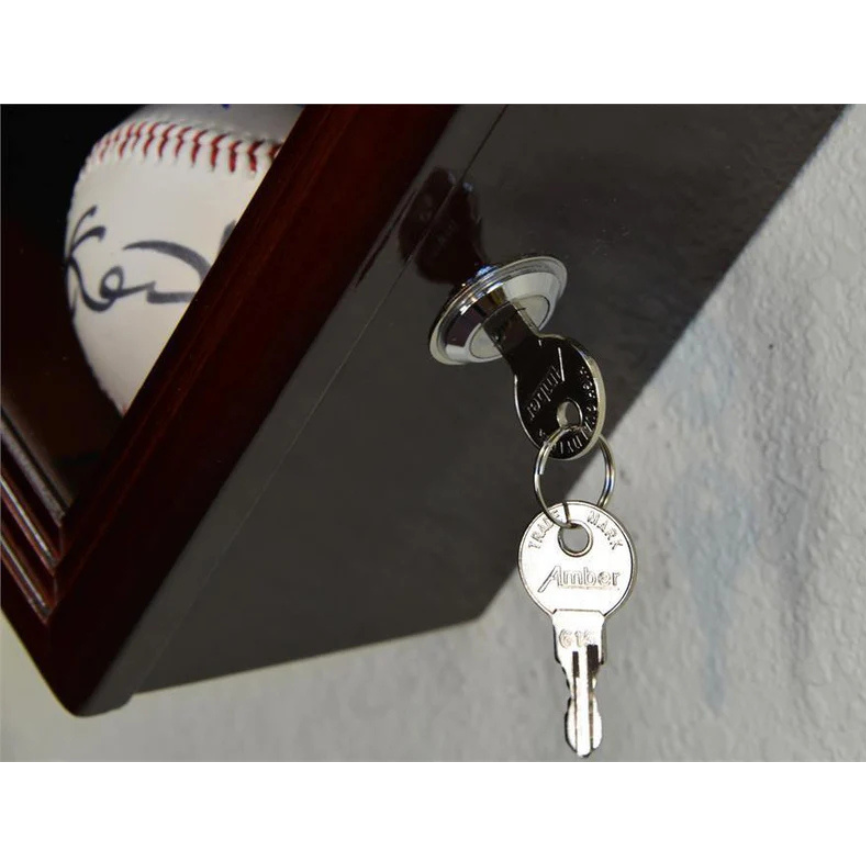 Key inserted into a lock with a baseball in the background. Baseball Display Case Holder.