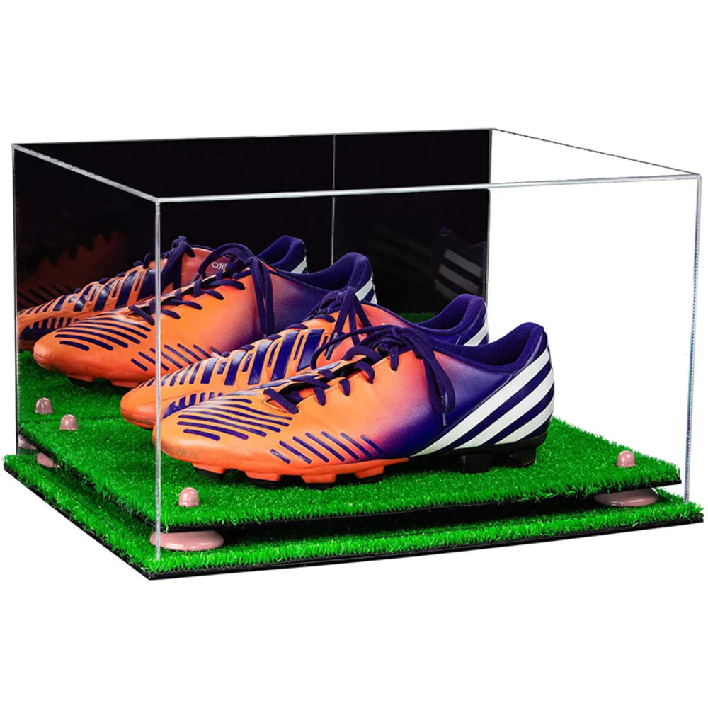 Orange and purple soccer cleats in a clear display case on artificial grass