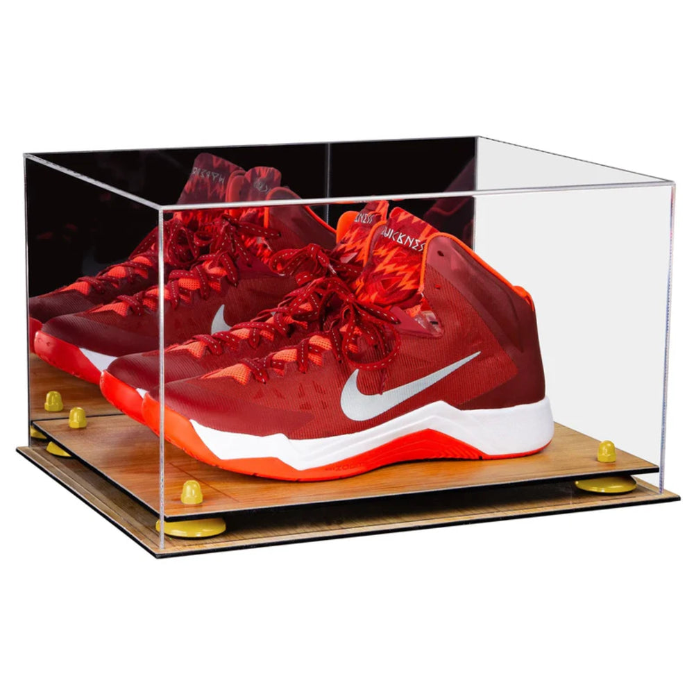 Red sneakers with a white logo in a clear display case on a wooden base.