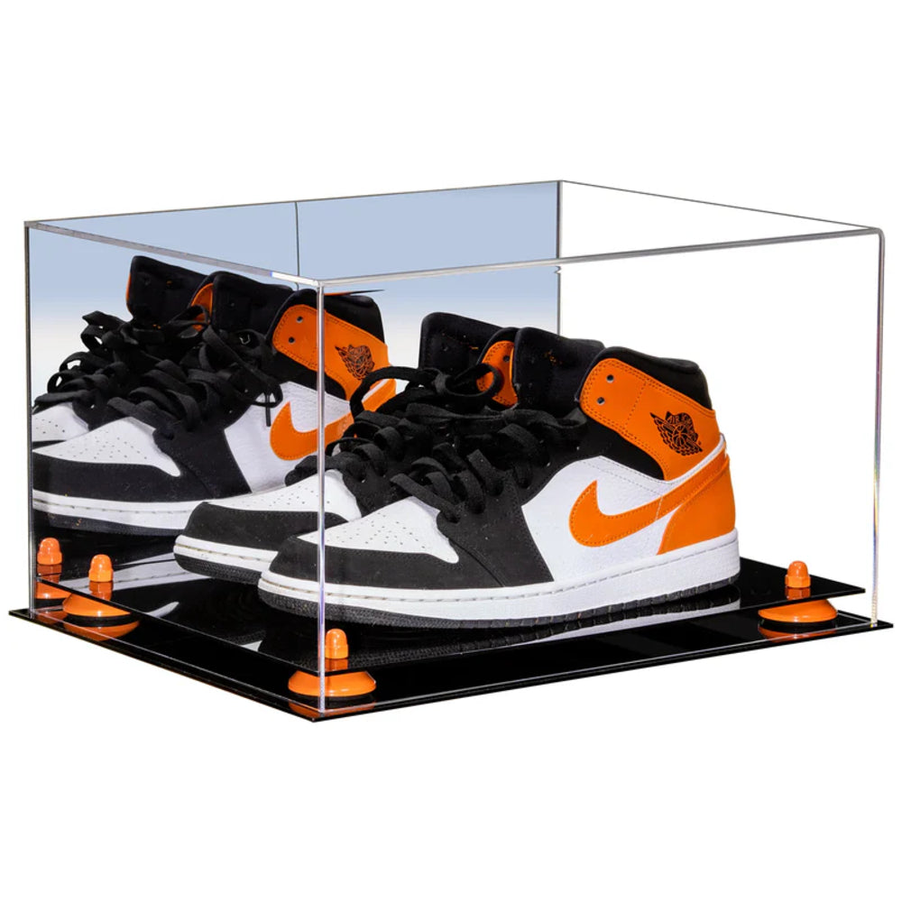 Black and orange sneakers in a clear display case on a white background