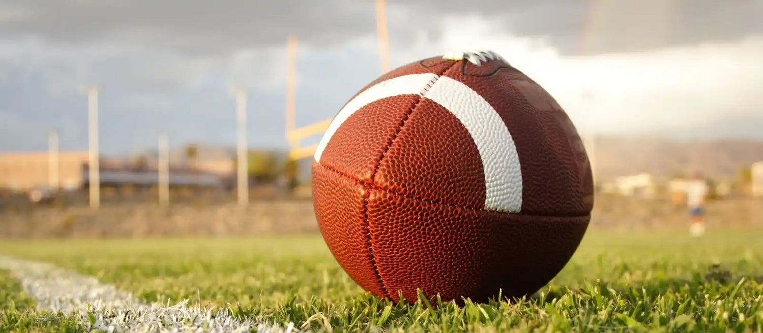 Autographed football displayed in a protective football ball display case for sports memorabilia collectors