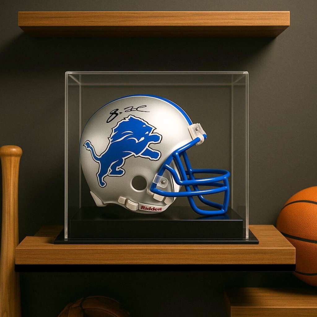 Autographed football helmet in a clear display case on a wooden shelf with a basketball in the background.
