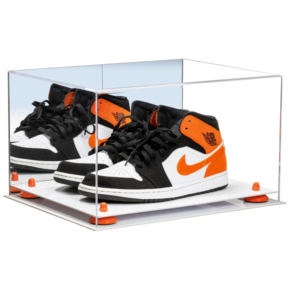 Black and orange sneakers in a clear display case on a white background